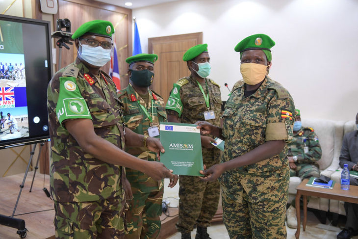 Somalia (AMISOM) in charge of Operations and Plans, Maj. Gen. William Kitsao Shume awards a certificate to an AMISOM officer at the closing of a joint AMISOM and SNA officers training on civil